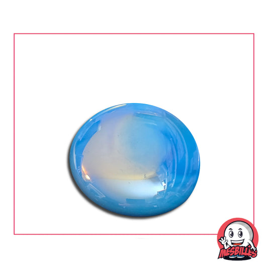 Une grande bille plate, également nommée Bille Galet en Verre, de la famille des Billes Glossys. Cette bille forme est ronde, légèrement ovoïde et mesure environ 3 cm de diamètre